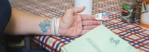 Person putting stamp on mail in ballot