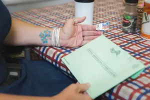 Person putting stamp on mail in ballot