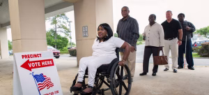Wheelchair user rolling past precinct sign