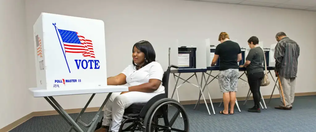 wheelchair user voting at foldable table